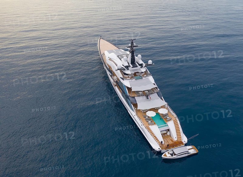 Aerial view of 109 metre motor yacht Bravo Eugenia, delivered in 2018 by the Dutch shipyard Oceanco to owner Jerry Jones, at anchor off the Principality of Monaco, behind Roquebrune Cap Martin, France, Cote d'Azur, Mediterranean Sea, Europe