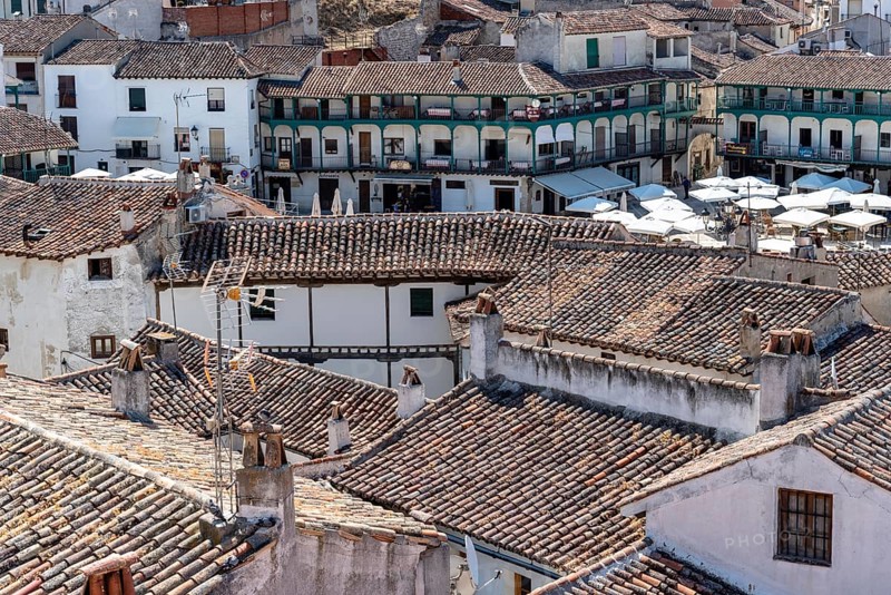 Chinchon, Spain, June 26, 2021: Aerial view of central Chinchon with Plaza Mayor, typical houses with wooden balconies and tile roofs. Sunny day of summer, Europe