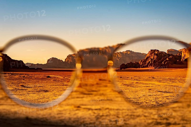 View at the Wadi Rum desert in Jordan through glasses during a nice sunset with clear sky. Travel, tourism and adventure