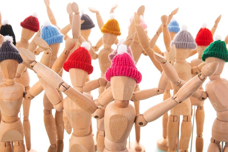 Many wooden mannequins with winter hat isolated over white