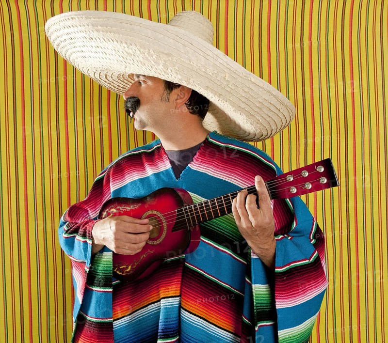 Mexican man serape poncho sombrero playing guitar typical Mexico