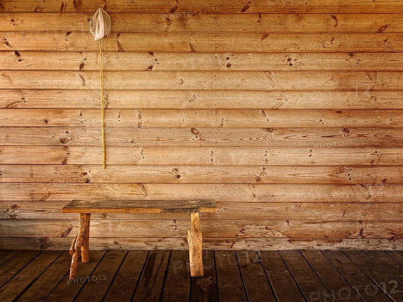 Butterfly net and bench against wooden wall