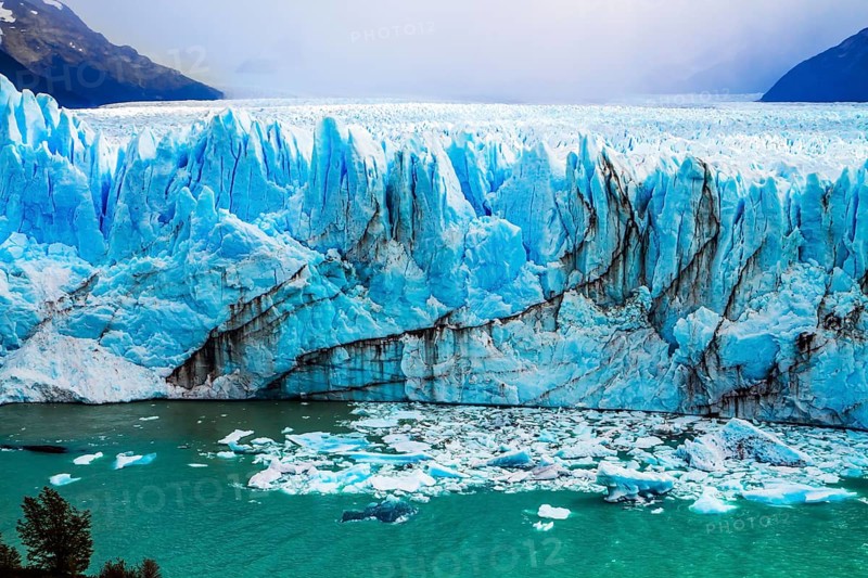 The colossal Glacier Perito Moreno in Patagonia on Lake Argentino. The cloudy sky covers the horizon. The concept of active and ecological tourism