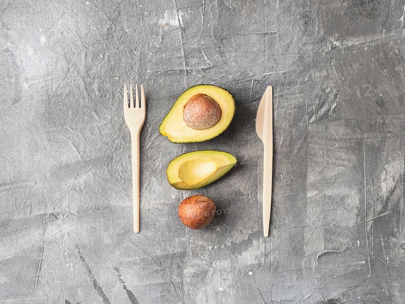 Avocado Seeds Biodegradable Single-Use Cutlery. Bioplastic - Great alternative to plastic disposable cutlery. Top view, flat lay. Copy space for text or design. Gray background
