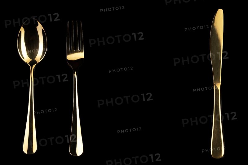 Golden knife and spoon on a black background. Cutlery