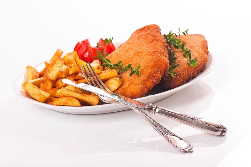 Pork schnitzel with chips on a porcelain plate