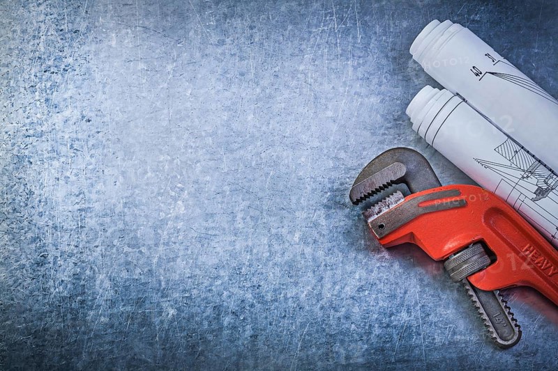 Monkey wrench construction plans on metallic background plumbing concept