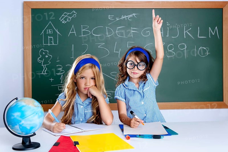 Smart nerd student in classroom raising hand with sad friend