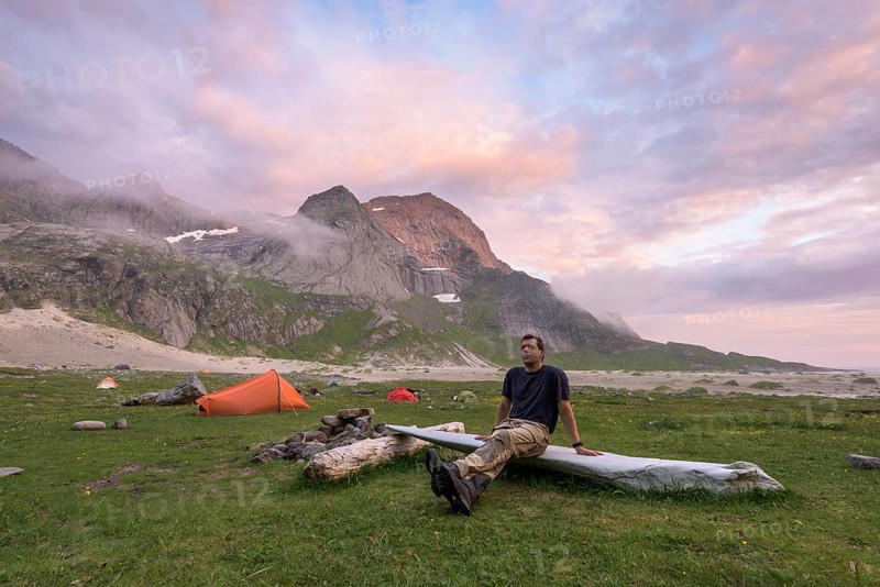 Man resting by the tent, Buneset, Moskenesöya, Lofoten, Nordland, Norway, July 2015, Europe