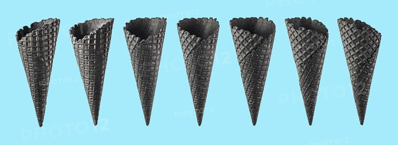 Various ice cream cones isolated on blue background. Various perspective of black waffle sugar cones on bright blue background