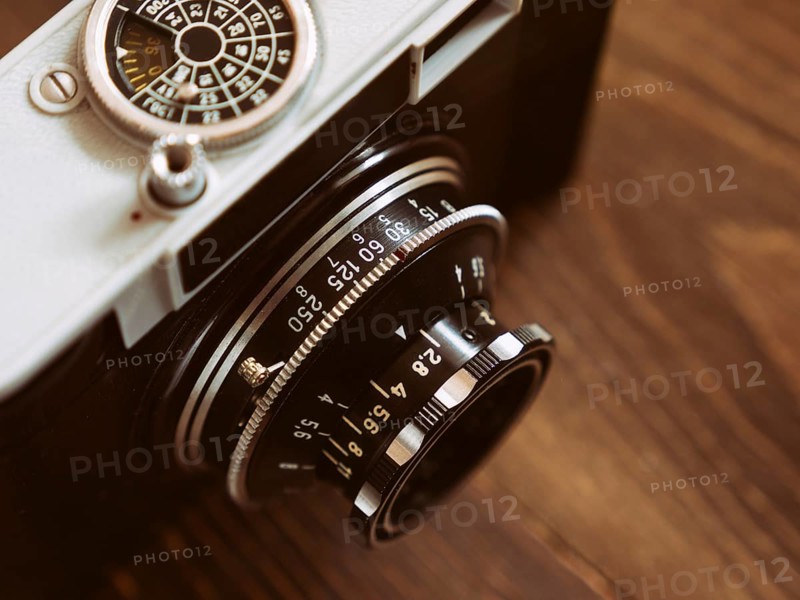 Close up photo of old vintage camera lens over wooden table. selective focus