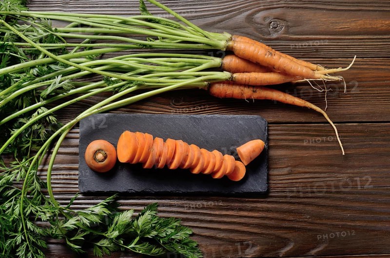 Top view at fresh organic Carrots on kitchen wooden table