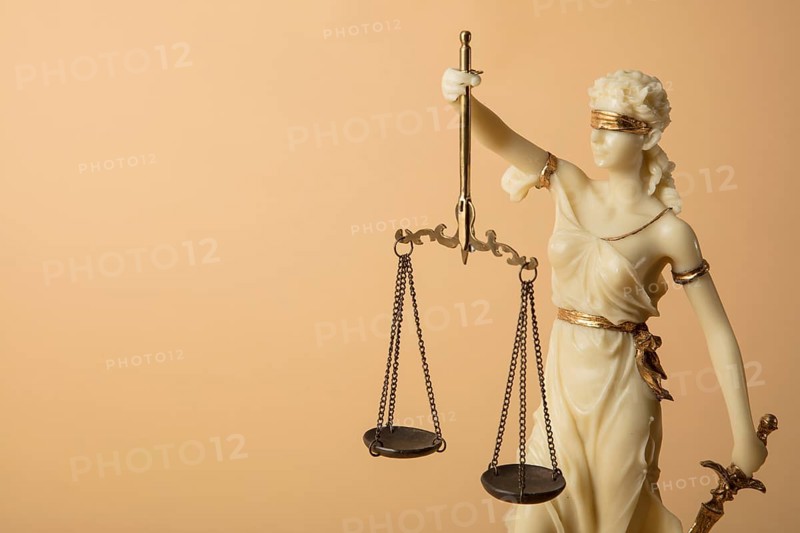 Justizia Figur auf beige Hintergrund