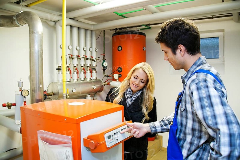 Young heating technician in boiler room at Heizanlage Austria