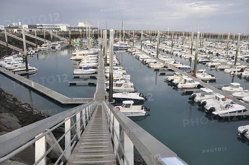Saint-Quay Portrieux, A marina filled with white boats and docks under an overcast sky, viewed from a descending walkway