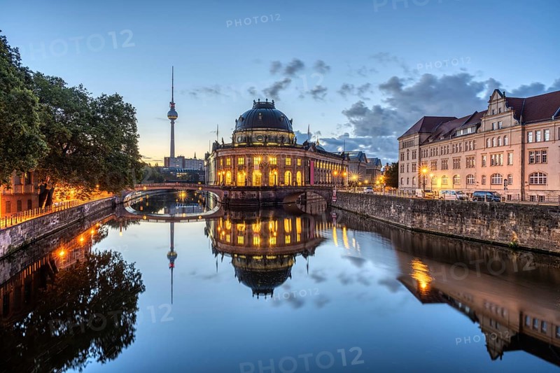 The Bode Museum and the television tower are reflected in the Spree in Berlin in front of sunrise