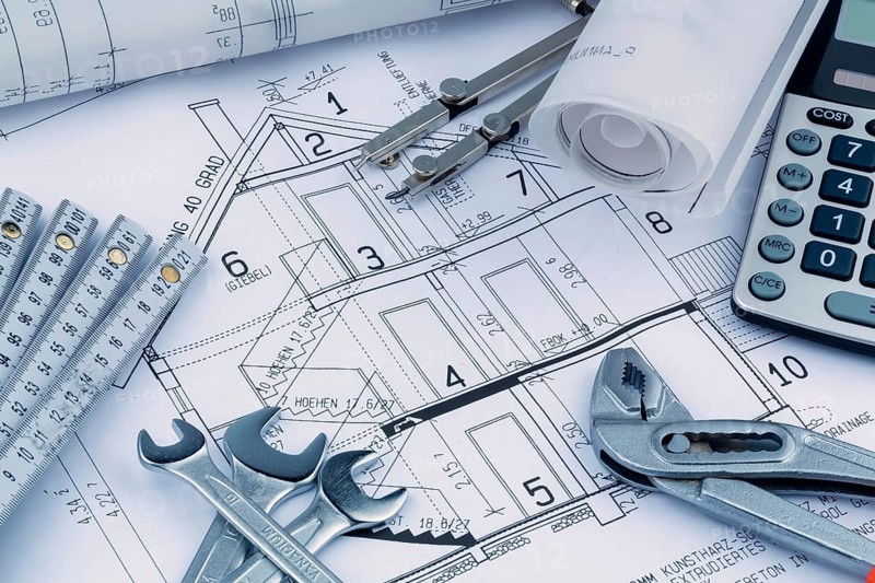 An architect's construction plan with a calculator. Symbolic photo for financing and planning a new house. Austria