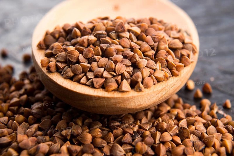 Buckwheat seeds on wooden spoon in closeup, lodz, poland