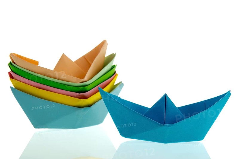 Colorful folded paper boats isolated over white background