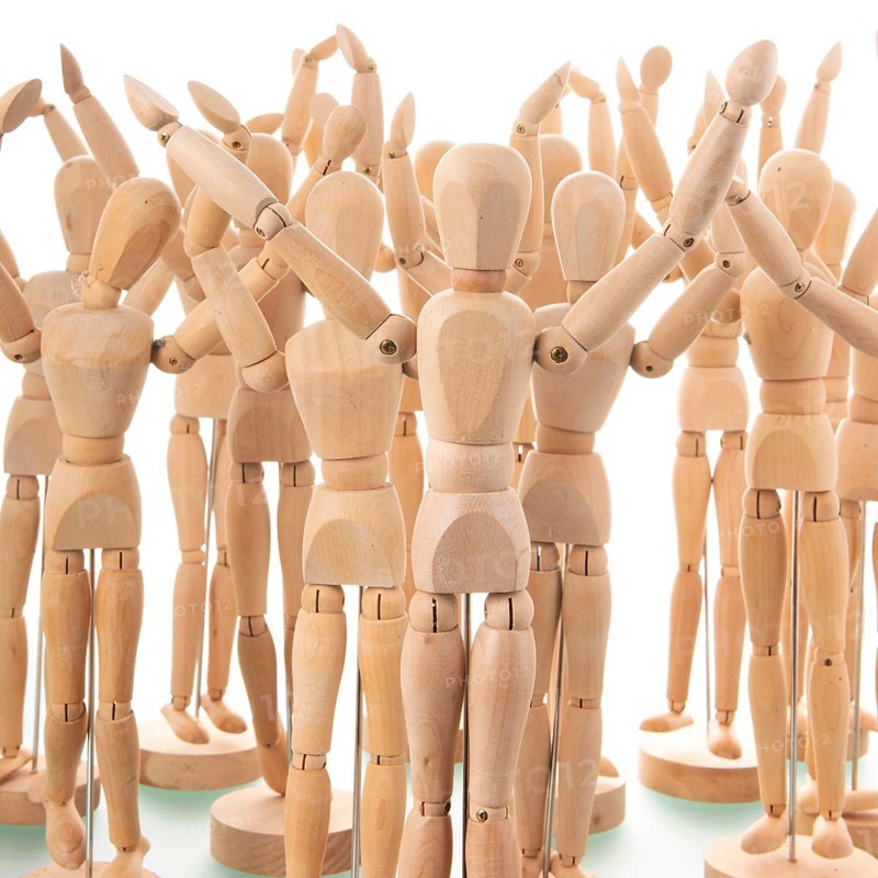 Many wooden mannequins isolated over white