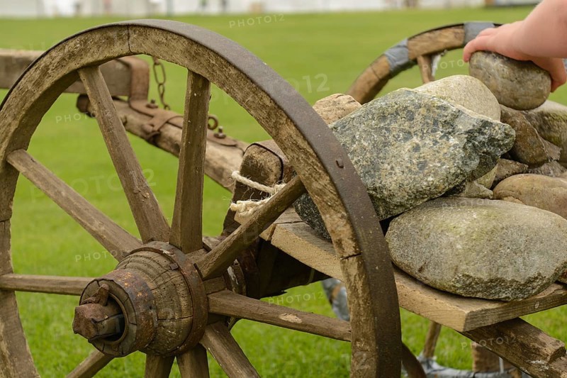Stones are loaded onto an old wooden cart - close-up