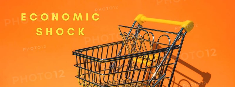 ECONOMIC SHOCK text Empty shopping trolley cart on colorful orange background. Online shopping, buy mall market shop consumer concept. Small toy supermarket grocery push cart. Rising food cost, grocery prices shortage mass hunger. Inflation