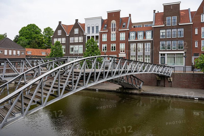 Hulst, Zeeland, The Netherlands, May 21, 2023, Pedestrian bridge and historical buildings at the water of the canal in old town, Europe