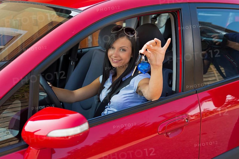 Young woman with new car and car keys