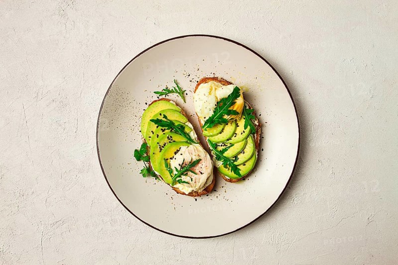 Sandwich with cream cheese, sliced avocado and boiled egg, arugula, on grainy bread, homemade, breakfast, no people