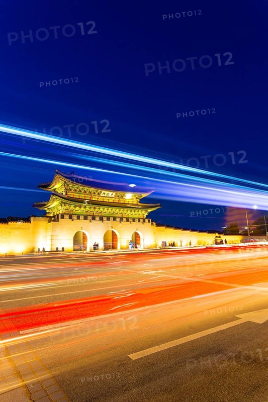 Colorful streaks of light from car lights on moving traffic in front of historic Gyeongbokgung Palace, Gwanghwamun entrance gate at dusk in downtown Seoul, South Korea, Asia
