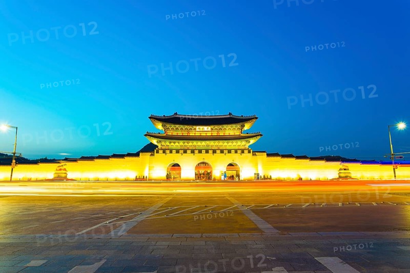 Long exposure car lights leaving a straight light trail in front of Gwanghwamun main entrance gate to Gyeongbokgung Palace in historic part of downtown on a clear, twilight night in Seoul, South Korea, Asia