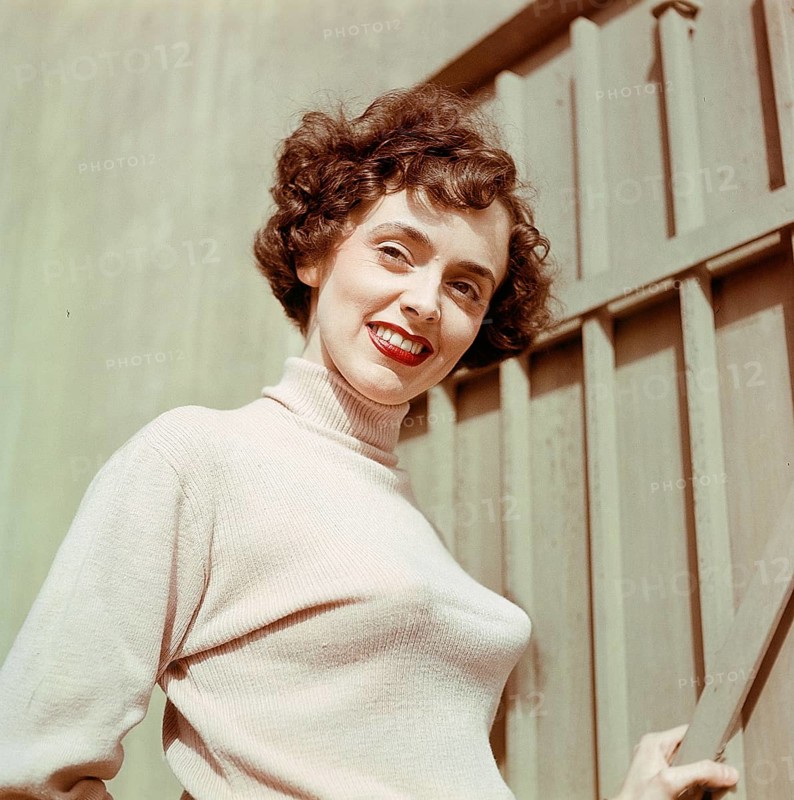 1950s jumper fashion. A swedish young woman wearing a typical 50s sweater. Under it she is wearing a bullet bra. The popular type of bra had bra cups in the shape of a paraboloid and was made popular due to sweater girl pin-ups. Sweden 1950s. CV5-10