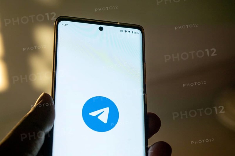 Smartphone on surface showing Telegram logo