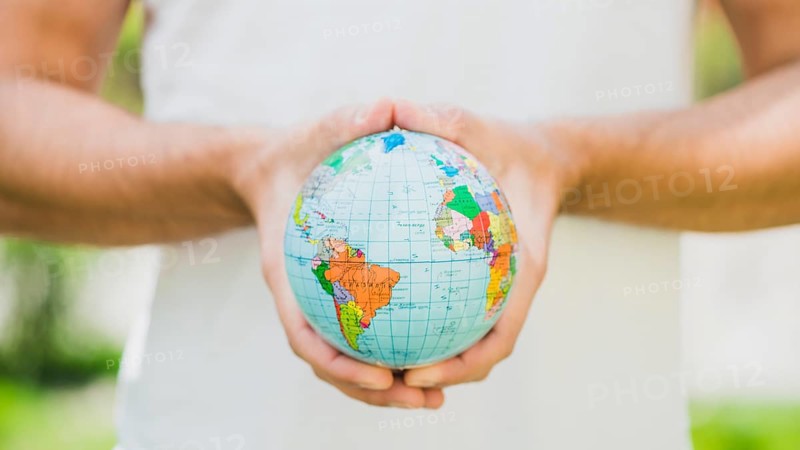 Close up man s hand holding small globe
