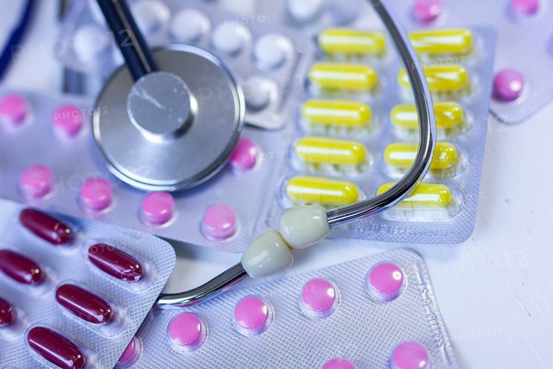Various medication blister packs and a stethoscope on a table
