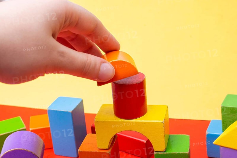 Hand building tower with colorful building blocks