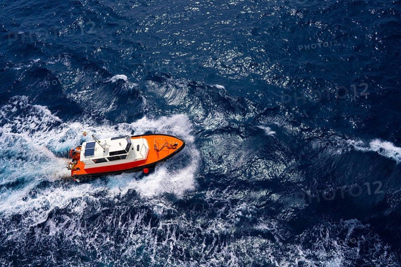 Pilots boat aerial view sailing in blue ocean sea with foam wake
