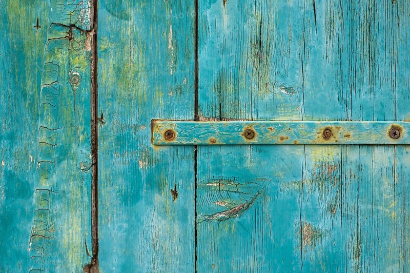 Old wooden door with peeling paint and iron fittings, texture, background, Montenegro, Balkans, Europe