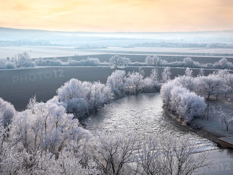 View of the river Unstrut in the Unstrut valley in winter at dawn, fields and trees covered with hoarfrost, Memleben, Saxony-Anhalt, Germany, Europe