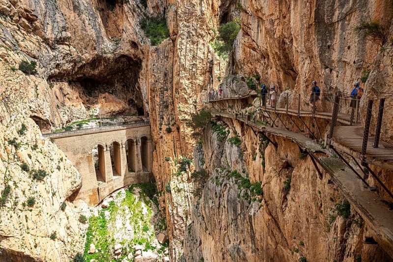 View of a viaduct and hikers on the Caminito del Rey path, embedded in a rocky gorge, Malaga, Spain, Europe