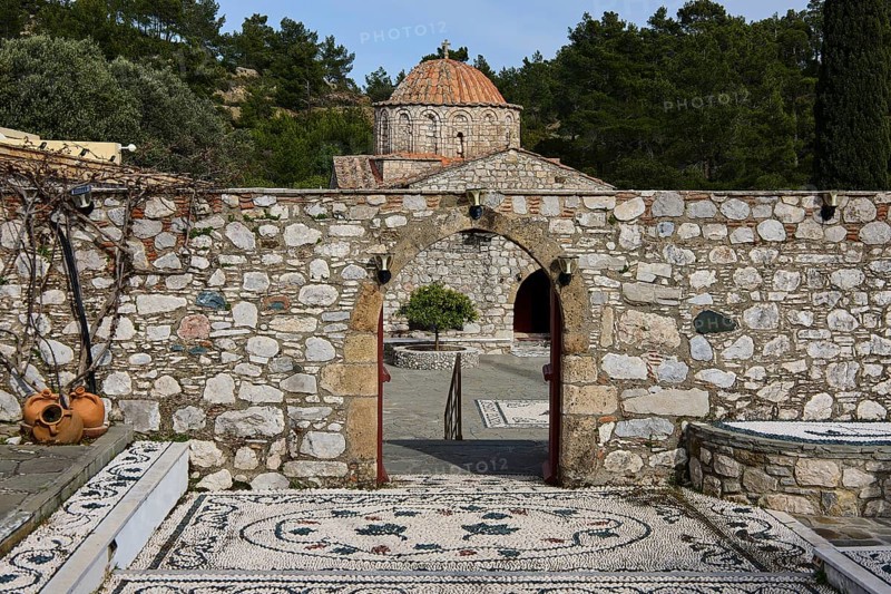 Path of mosaic stones leads to a church, surrounded by a high stone wall and trees, Thari Monastery, Moni Thari, near Gadouras Reservoir, lonely mountain region, Rhodes, Dodecanese, Greek Islands, Greece, Europe