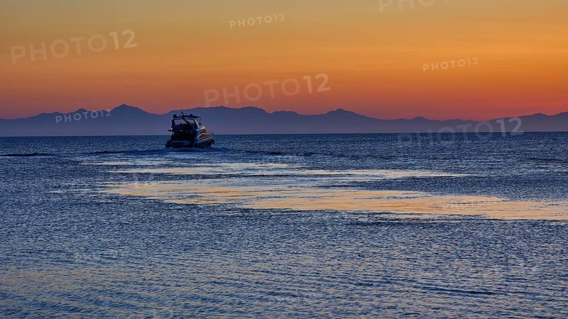 Lonely boat on the sea with mountains in the background, sunrise, dawn, Fort of Saint Nikolaos, Mandraki harbour, Rhodes town, Rhodes, Dodecanese, Greek Islands, Greece, Europe