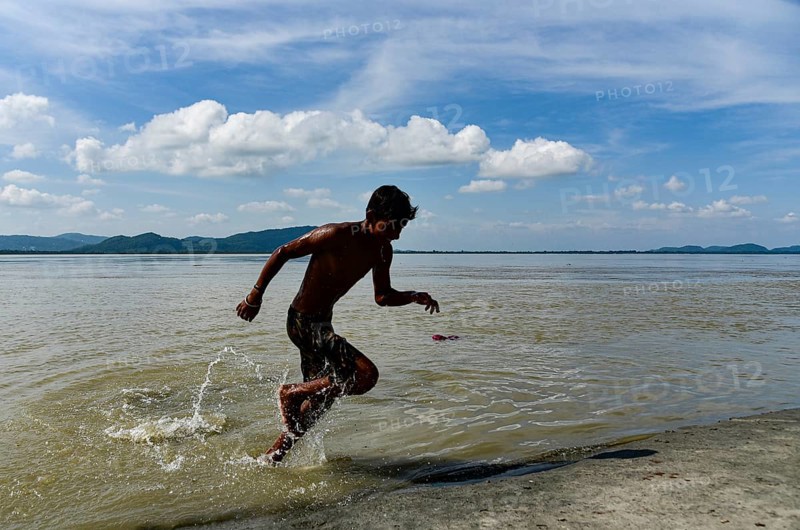 Boys jump in the Brahmaputra river during an a hot summer day in Guwahati, india on July 11, 2022