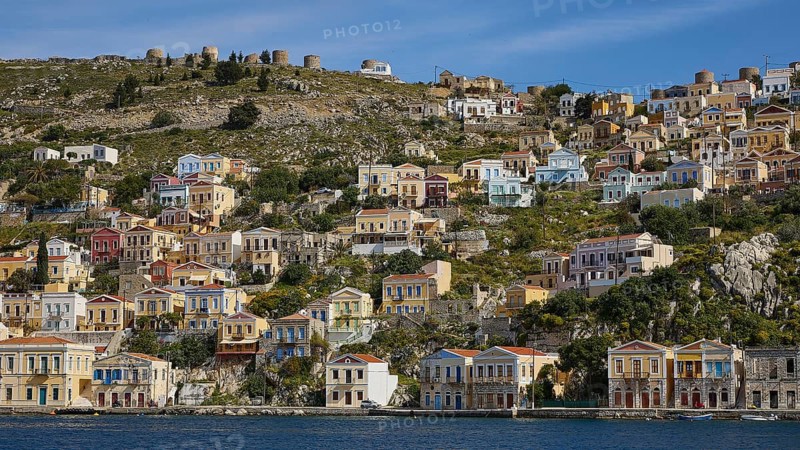 Colourful harbour village on a hill with traditional Greek architecture, Symi Town, Symi, Dodecanese, Greek Islands, Greece, Europe