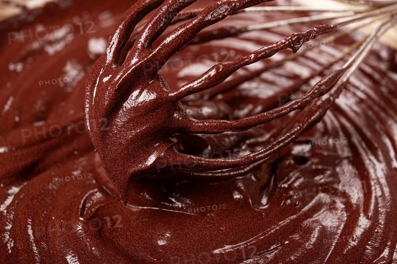 A bowl of chocolate dough, a whisk for whipping, baking, structure and consistency, homemade, top view, no people