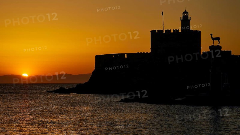 Majestic silhouette of a fortress against a glowing sunrise, dawn, Fort of Saint Nikolaos, Mandraki harbour, Rhodes town, Rhodes, Dodecanese, Greek Islands, Greece, Europe