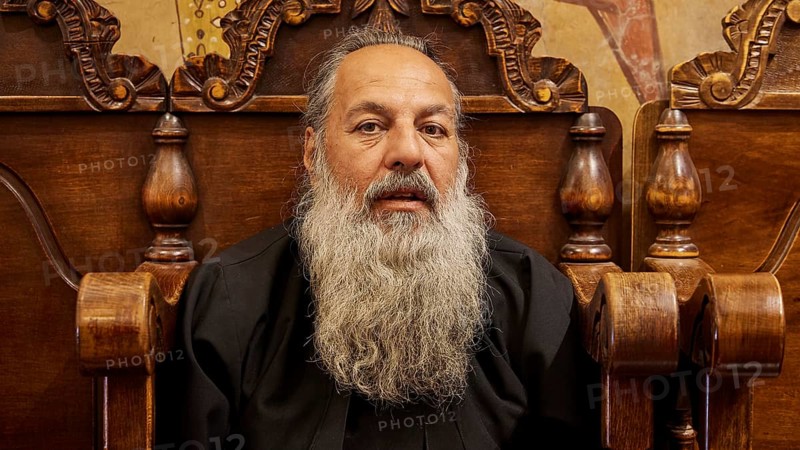 Portrait of a bearded man in black clothes, sitting on a wooden chair, Papas Nektarios, Monastery Thari, Moni Thari, near Gadouras Reservoir, lonely mountain region, Rhodes, Dodecanese, Greek Islands, Greece, Europe