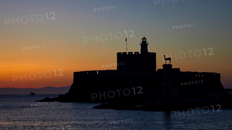 Fortress by the sea silhouetted against a colourful sunrise, dawn, Fort of Saint Nikolaos, Mandraki Harbour, Rhodes Town, Rhodes, Dodecanese, Greek Islands, Greece, Europe