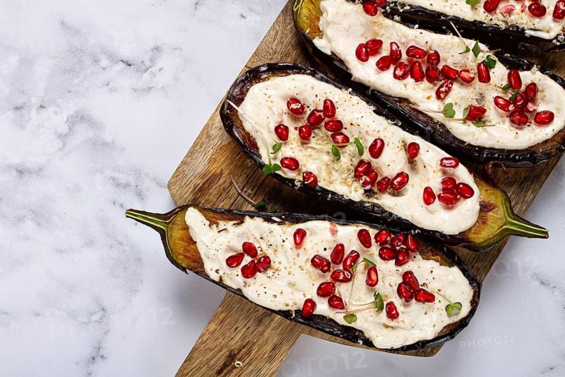 Fried eggplant with sauce, decorated with microgreens and pomegranate seeds, eggplant appetizer, top view, homemade, no people