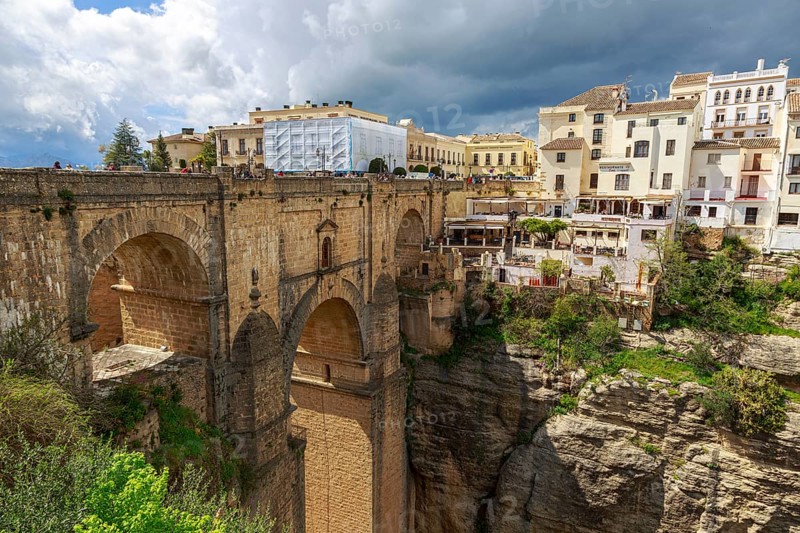 The imposing Puente Nuevo bridge in Ronda, which crosses a deep ravine, surrounded by historic buildings, Ronda, Spain, Europe